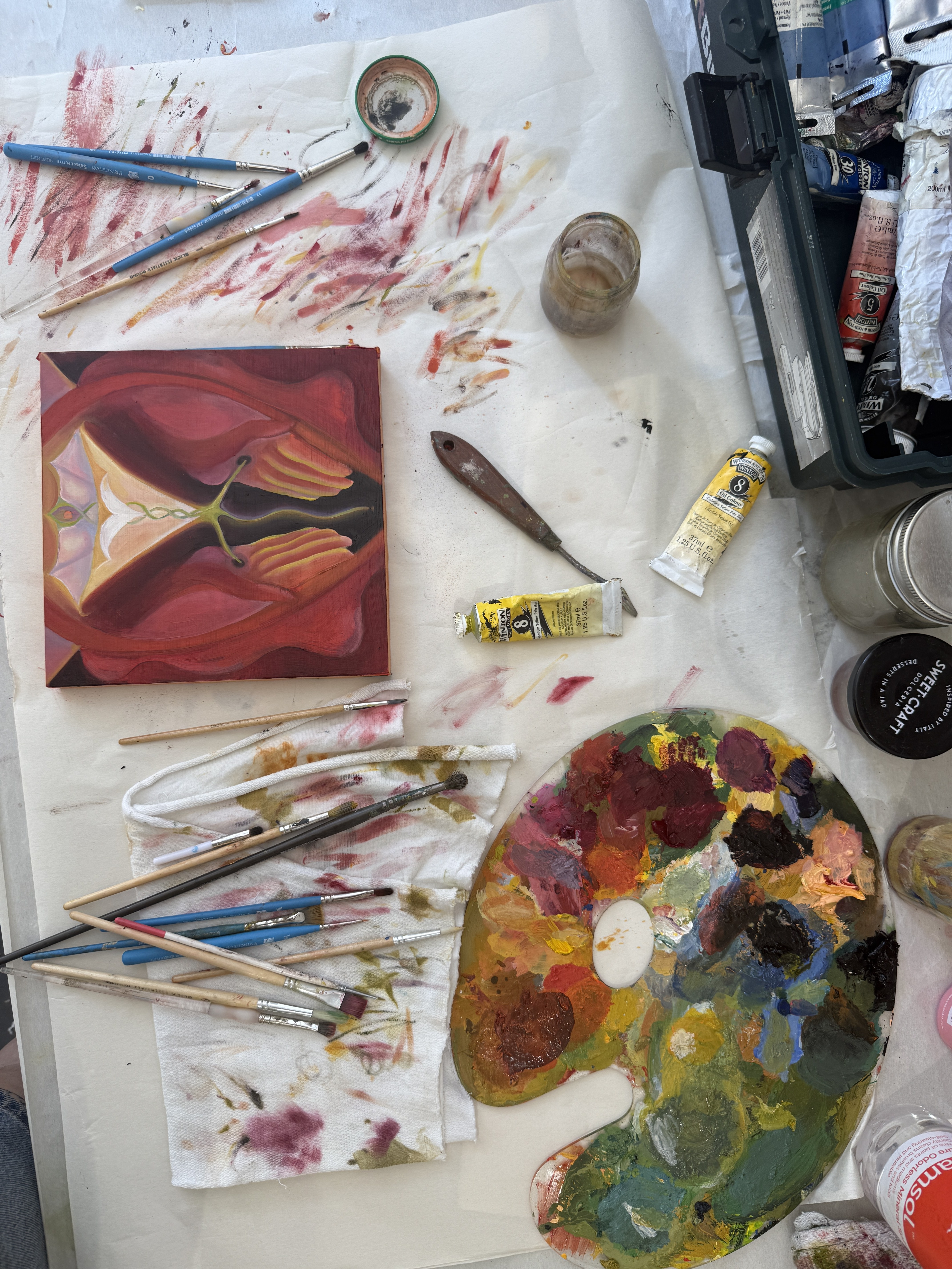 Palette, brushes, and a painting in progress