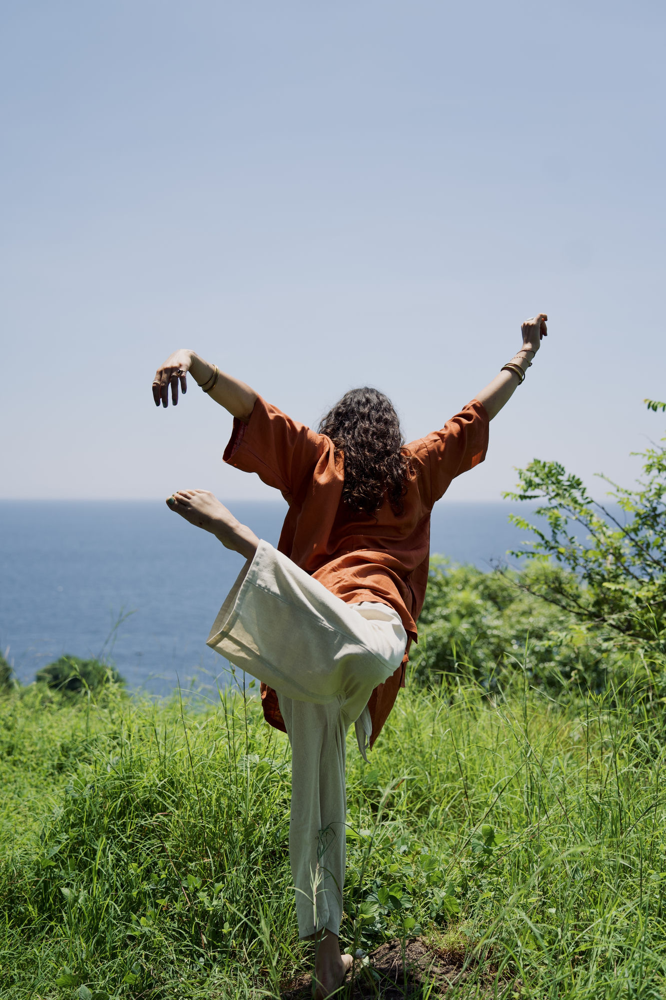 Quincee Lark dancing with arms raised at the horizon